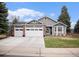 Charming home featuring a three car garage, well-manicured lawn, and attractive brick and siding details at 9705 Westbury Cir, Highlands Ranch, CO 80129