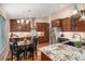 Spacious kitchen featuring granite countertops, dark wood cabinets, stainless steel appliances, and an eat-in area at 9705 Westbury Cir, Highlands Ranch, CO 80129
