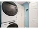 Efficient laundry room with stacked washer/dryer and ample storage at 9705 Westbury Cir, Highlands Ranch, CO 80129