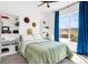 Cozy bedroom featuring natural light, a ceiling fan, and built-in bookshelves at 4706 Mesa Top Dr, Monument, CO 80132