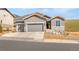 Charming single-Gathering home featuring a three-car garage, stone accents, and xeriscaped front yard at 4706 Mesa Top Dr, Monument, CO 80132