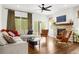 Cozy living room with a stone fireplace, hardwood floors, and large windows overlooking the backyard at 4706 Mesa Top Dr, Monument, CO 80132