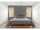 Main bedroom features a bed with a gray headboard, windows with wicker lamps, and gray carpet at 4706 Mesa Top Dr, Monument, CO 80132