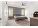 Main bedroom features a bed with a gray headboard, windows with wicker lamps, and gray carpet at 4706 Mesa Top Dr, Monument, CO 80132