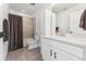 Bright bathroom featuring a shower-tub combo, modern vanity, and neutral tile flooring at 2548 Horsehound Pl, Castle Rock, CO 80104