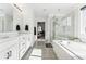 Luxurious bathroom featuring a double vanity, glass-enclosed shower, and a soaking tub for relaxation at 2548 Horsehound Pl, Castle Rock, CO 80104