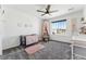 Bedroom with ceiling fan and carpet has a crib and overlooks neighborhood through large window at 2548 Horsehound Pl, Castle Rock, CO 80104