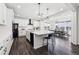 Modern kitchen with white cabinets, black appliances, large island, and an adjacent dining area at 2548 Horsehound Pl, Castle Rock, CO 80104