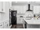 Modern kitchen featuring white cabinets, stainless steel appliances, and a large island with quartz countertop at 2548 Horsehound Pl, Castle Rock, CO 80104