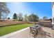 Backyard featuring a wooden deck with outdoor dining set, green lawn, and privacy fence at 5872 Taft St, Arvada, CO 80004