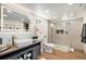 Modern bathroom with walk-in shower, wooden vanity, and bright lighting at 5872 Taft St, Arvada, CO 80004