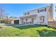 Charming two-story home with a well-maintained lawn, dark garage door and a covered front porch with seating at 5872 Taft St, Arvada, CO 80004