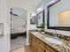 Bathroom with double sinks with granite countertops and a view into the bedroom at 5130 Morning Glory Pl, Highlands Ranch, CO 80130