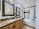 Bathroom with granite countertops, double sinks, and a bathtub with a shower at 5130 Morning Glory Pl, Highlands Ranch, CO 80130
