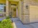 Inviting front entrance with brick accents, a wreath on the door, and charming details at 5130 Morning Glory Pl, Highlands Ranch, CO 80130