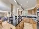 Spacious kitchen featuring granite countertops, wooden cabinets, and a central island cooktop at 5130 Morning Glory Pl, Highlands Ranch, CO 80130