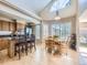 Eat-in kitchen with a vaulted ceiling, island seating, and lots of natural light at 5130 Morning Glory Pl, Highlands Ranch, CO 80130