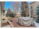 A brick patio features mature trees and covered furniture, creating an inviting outdoor living space at 6328 S Ouray Way, Aurora, CO 80016