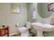 A charming powder room features pedestal sink, decorative mirror, and neutral wall color at 6328 S Ouray Way, Aurora, CO 80016