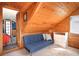 Cozy attic space with wood planking, futon, dresser and dormer window at 3521 W 40Th Ave, Denver, CO 80211