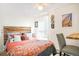 Cozy bedroom featuring a wooden headboard, colorful bedding, and a window with natural light at 3521 W 40Th Ave, Denver, CO 80211