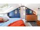 Attic bedroom featuring blue walls, wood floors, skylight, and en-suite bathroom at 3521 W 40Th Ave, Denver, CO 80211