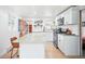 Bright and modern kitchen with white cabinets, stainless appliances, a kitchen island, and a view to a wooden door at 3521 W 40Th Ave, Denver, CO 80211