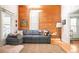 Cozy living room featuring hardwood floors, a comfortable gray sectional sofa, and a stylish accent wall at 3521 W 40Th Ave, Denver, CO 80211