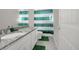 Well-lit bathroom features white cabinets, granite countertops, patterned floor tiles, and a green-and-white striped shower curtain at 118 N Newcastle Way, Aurora, CO 80018