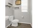 This half bathroom features gray walls, wood flooring, a wall-mounted sink, floating shelves, and updated decor at 118 N Newcastle Way, Aurora, CO 80018
