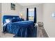 This cozy bedroom features a comfortable blue bed, soft carpet, and natural light from a window at 118 N Newcastle Way, Aurora, CO 80018