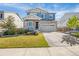 Two-story home with stone accents, blue siding, and a spacious front yard and driveway at 118 N Newcastle Way, Aurora, CO 80018