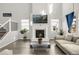 Cozy living room featuring a fireplace, large windows, a two-story ceiling, and stylish decor at 118 N Newcastle Way, Aurora, CO 80018