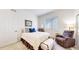 Comfortable bedroom with a cozy chair, a window, and a well-lit desk space at 22674 E Henderson Dr, Aurora, CO 80016