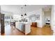 Open concept kitchen with stainless appliances, stone countertops and hardwood floors leading to a dining area at 22674 E Henderson Dr, Aurora, CO 80016