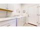 Laundry room features white cabinets, a utility sink, and a front-loading washer and dryer at 22674 E Henderson Dr, Aurora, CO 80016