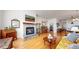 Living room with a stone fireplace, hardwood floors, and open to dining area at 22674 E Henderson Dr, Aurora, CO 80016