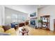 Cozy living room with a stone fireplace, hardwood floors, and bright windows at 22674 E Henderson Dr, Aurora, CO 80016