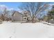 Spacious backyard with snow covered lawn and partially visible patio at 325 Lodgewood Ln, Lafayette, CO 80026