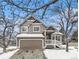 Two-story house with taupe exterior, snowy front yard, and attached garage at 325 Lodgewood Ln, Lafayette, CO 80026