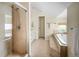 Bathroom showcasing a glass-enclosed shower, a soaking tub, and neutral tiling at 2434 S Williams St, Denver, CO 80210
