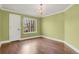 Cozy bedroom with hardwood floors, a chandelier, and a bright window at 13732 E Lehigh Ave # H, Aurora, CO 80014