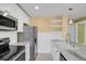 Well-lit kitchen featuring stainless steel appliances, open shelving, and marble countertops at 13732 E Lehigh Ave # H, Aurora, CO 80014