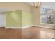 Bright living room featuring hardwood floors, high ceilings, a large window, and modern lighting fixture at 13732 E Lehigh Ave # H, Aurora, CO 80014