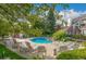 Community pool surrounded by trees, landscaping, and seating at 13732 E Lehigh Ave # H, Aurora, CO 80014