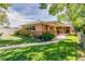 Single story home with brick and covered front porch and manicured lawn at 1432 Xanthia St, Denver, CO 80220