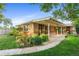 Charming brick home with a covered front porch and lush landscaping at 1432 Xanthia St, Denver, CO 80220