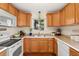Functional kitchen with white appliances, oak cabinets, and a cozy atmosphere at 1432 Xanthia St, Denver, CO 80220