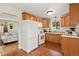 Well-lit kitchen with oak cabinets, white appliances, and unique tile flooring at 1432 Xanthia St, Denver, CO 80220