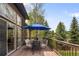 Spacious back deck features an outdoor dining area with peaceful views of the surrounding greenery at 1654 Muirfield Ln, Evergreen, CO 80439